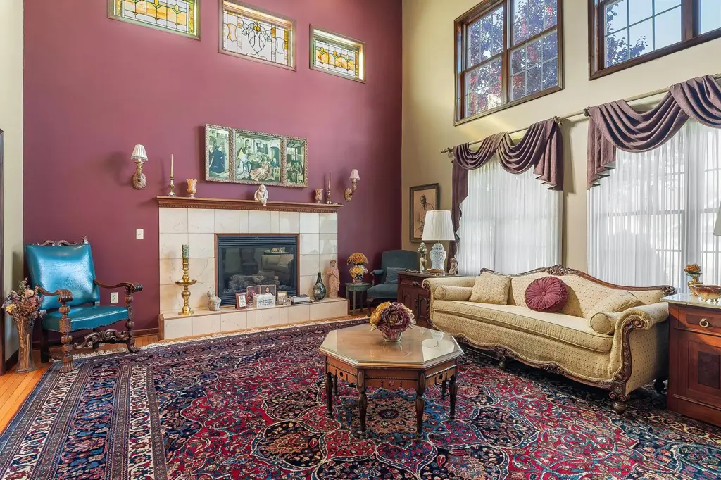 Formal living room with a tiled fireplace, tall windows and stained glass transoms