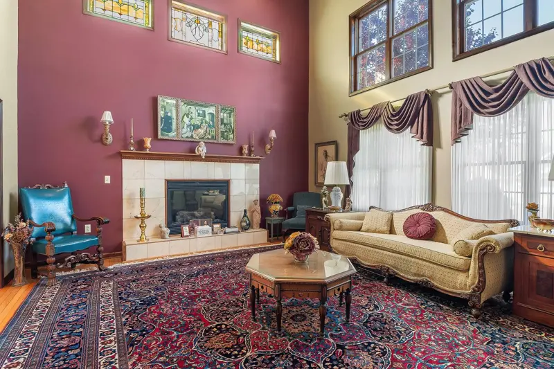 Formal living room with a tiled fireplace, tall windows and stained glass transoms