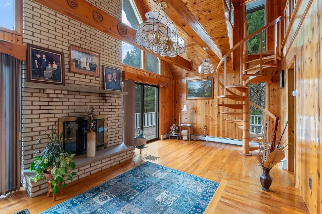 Great room with a brick fireplace, pine ceiling and spiral staircase in a Northeastern Pennsylvania home