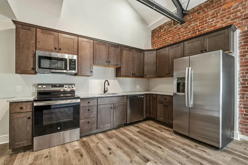 Kitchen with wood cabinets and an exposed brick wall
